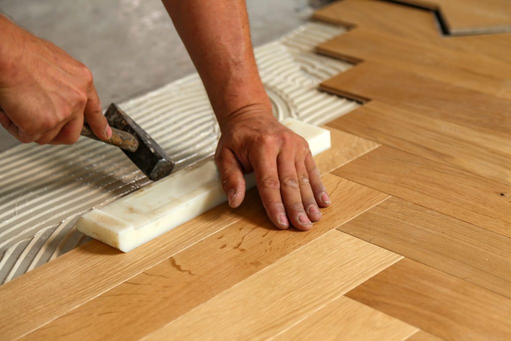 Sobre nosotros Worker installing parquet flooring